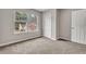 This carpeted bedroom features a closet with a white door and neutral walls at 1138 School Side Dr, Lithonia, GA 30058