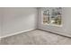 This carpeted bedroom has neutral walls and a large window that lets in plenty of natural light at 1138 School Side Dr, Lithonia, GA 30058