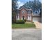 Charming two-story brick home featuring a well-manicured lawn, front garden, and a two-car garage at 1138 School Side Dr, Lithonia, GA 30058