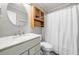 Cozy bathroom with white marble sink, wooden medicine cabinet, and shower with white curtain at 3274 Ridgecrest Se Rd, Smyrna, GA 30080