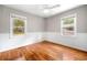 Bright bedroom featuring hardwood floors, paneled walls, and two windows for natural light at 3274 Ridgecrest Se Rd, Smyrna, GA 30080