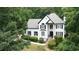 Charming two-story home boasts a black and white design, surrounded by lush landscaping and mature trees at 3290 Cherry Oak Ln, Cumming, GA 30041