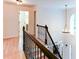 Hallway with hardwood floors, wrought iron banister, and view of the entry at 3290 Cherry Oak Ln, Cumming, GA 30041