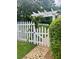 Charming white picket fence gate with climbing vines, nestled within a lush backyard setting at 3532 W Hampton Nw Dr, Marietta, GA 30064