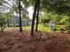 A sprawling backyard showcasing a play set, mature trees, and an inviting outdoor space at 3532 W Hampton Nw Dr, Marietta, GA 30064