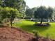 Expansive backyard featuring a play set, white picket fence, and mature trees at 3532 W Hampton Nw Dr, Marietta, GA 30064