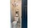 Cozy powder room with a white toilet, a black metal rack, and elegant chandelier at 3532 W Hampton Nw Dr, Marietta, GA 30064