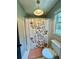 Functional bathroom with a patterned shower curtain, simple toilet, and natural light at 3532 W Hampton Nw Dr, Marietta, GA 30064