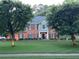 Charming brick home with manicured lawn and inviting front porch featuring rocking chairs at 3532 W Hampton Nw Dr, Marietta, GA 30064
