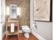 Elegant half bathroom featuring tile accent wall, wood floors, decorative vanity, and stylish fixtures at 1065 Peachtree Ne St # 3505, Atlanta, GA 30309