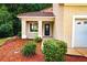 Inviting front entrance featuring a decorative door, manicured landscaping, and a cozy, covered porch at 128 Garden Walk, Stockbridge, GA 30281