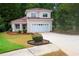 Charming two-story home boasts a lush front lawn, manicured shrubbery, and a convenient two-car garage at 128 Garden Walk, Stockbridge, GA 30281