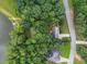 Aerial view of a home surrounded by lush trees, with a nearby fishing dock and access to a tranquil lake at 2990 Cove Crossing Dr, Lawrenceville, GA 30045