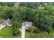 Picturesque aerial view of a home nestled among lush trees and foliage with a nearby pond at 2990 Cove Crossing Dr, Lawrenceville, GA 30045