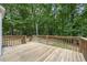 Large wooden back deck with railing offering scenic views of the wooded yard at 2990 Cove Crossing Dr, Lawrenceville, GA 30045