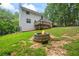 Stone fire pit offers a cozy gathering spot in the lush, private backyard with a deck above at 2990 Cove Crossing Dr, Lawrenceville, GA 30045