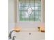Bright bathroom featuring a soaking tub with a decorative window and elegant fixtures, offering a relaxing retreat at 2990 Cove Crossing Dr, Lawrenceville, GA 30045