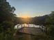 Scenic view of the sunrise from the wooden fishing dock, overlooking the calm lake surrounded by lush trees at 2990 Cove Crossing Dr, Lawrenceville, GA 30045