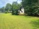 Expansive front yard offering ample green space, framed by mature trees and greenery at 2990 Cove Crossing Dr, Lawrenceville, GA 30045