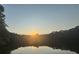 Picturesque sunset over a tranquil pond surrounded by trees, offering a serene view at 2990 Cove Crossing Dr, Lawrenceville, GA 30045