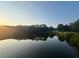 Scenic view of a tranquil pond at sunset, reflecting the surrounding trees and sky at 2990 Cove Crossing Dr, Lawrenceville, GA 30045