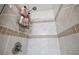 Close-up of a tiled shower featuring decorative accents and a convenient shower caddy for toiletries at 2990 Cove Crossing Dr, Lawrenceville, GA 30045