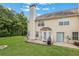 View of the backyard with a covered patio area, a grill, and a sprawling lawn perfect for outdoor enjoyment at 417 Red Coat Ln, Woodstock, GA 30188