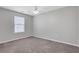 A bright bedroom features neutral walls, plush carpeting, and a ceiling fan for added comfort at 417 Red Coat Ln, Woodstock, GA 30188