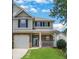 Inviting two-story home featuring a covered porch, attached garage, and lush green lawn at 417 Red Coat Ln, Woodstock, GA 30188