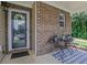 Cozy front porch with decorative brick, seating, and welcoming entrance at 417 Red Coat Ln, Woodstock, GA 30188
