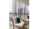 Relaxing balcony with two chairs and a table, featuring a spectacular view of city architecture at 620 Peachtree Ne St # 1206, Atlanta, GA 30308