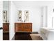 Bedroom dresser with art on the wall, hardwood floors and mirrored closet doors in the background at 620 Peachtree Ne St # 1206, Atlanta, GA 30308