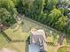 Aerial view of the home showcasing the expansive backyard, garden, firepit, and mature trees at 2385 Saddle Brook Trce, Cumming, GA 30040