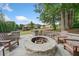 Stone firepit area with built-in seating and chairs, perfect for outdoor gatherings at 2385 Saddle Brook Trce, Cumming, GA 30040