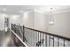 Hallway overlooking the living area with dark wood floors and railing at 2385 Saddle Brook Trce, Cumming, GA 30040