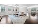 Bright living room with dark hardwood floors, large windows, and a view into the dining area at 2385 Saddle Brook Trce, Cumming, GA 30040
