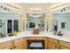 Bright bathroom vanity with double sinks, dressing table, and a large mirror at 271 Double Gate Ct, Sugar Hill, GA 30518