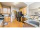 Well-lit kitchen features stainless steel appliances, granite countertops, and natural wood cabinets at 271 Double Gate Ct, Sugar Hill, GA 30518