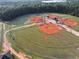 Aerial view of a well-maintained baseball field with covered dugouts surrounded by lush greenery at 2725 Bailey Ne Pl, Conyers, GA 30013