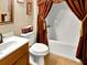 Cozy bathroom with tiled floors, toilet, vanity, and shower with decorative curtains at 2725 Bailey Ne Pl, Conyers, GA 30013