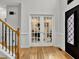 Welcoming entryway with hardwood floors, white-trimmed french doors, and black-trimmed front door at 2725 Bailey Ne Pl, Conyers, GA 30013