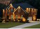 Stately brick home with manicured lawn, lit dramatically with landscape and architectural lighting at 2725 Bailey Ne Pl, Conyers, GA 30013
