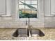 Close-up of a kitchen sink area with granite countertops, stainless steel fixtures, and a bright window view at 2725 Bailey Ne Pl, Conyers, GA 30013