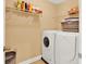 Practical laundry room with washer, dryer, and shelves for storing supplies at 2725 Bailey Ne Pl, Conyers, GA 30013