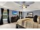 This main bedroom has tray ceilings, dark curtains, and a television at 2725 Bailey Ne Pl, Conyers, GA 30013