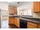 Kitchen with dark countertop and wood cabinets that opens to the dining area at 3262 Cascade Parc Blvd, Atlanta, GA 30311