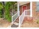 Close up of the home's entry featuring concrete steps, white railings, brick facade, and red front door at 3262 Cascade Parc Blvd, Atlanta, GA 30311