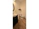 Powder room showcasing a dark vanity, an oval mirror, and hardwood flooring at 4162 Riverdale Dr, Snellville, GA 30039