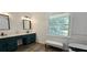 Bright bathroom features double sink vanity, a window with view and stylish accent bench at 4162 Riverdale Dr, Snellville, GA 30039