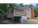 Side view of home featuring garage, brick chimney, neutral siding and complemented by professional landscaping at 4162 Riverdale Dr, Snellville, GA 30039